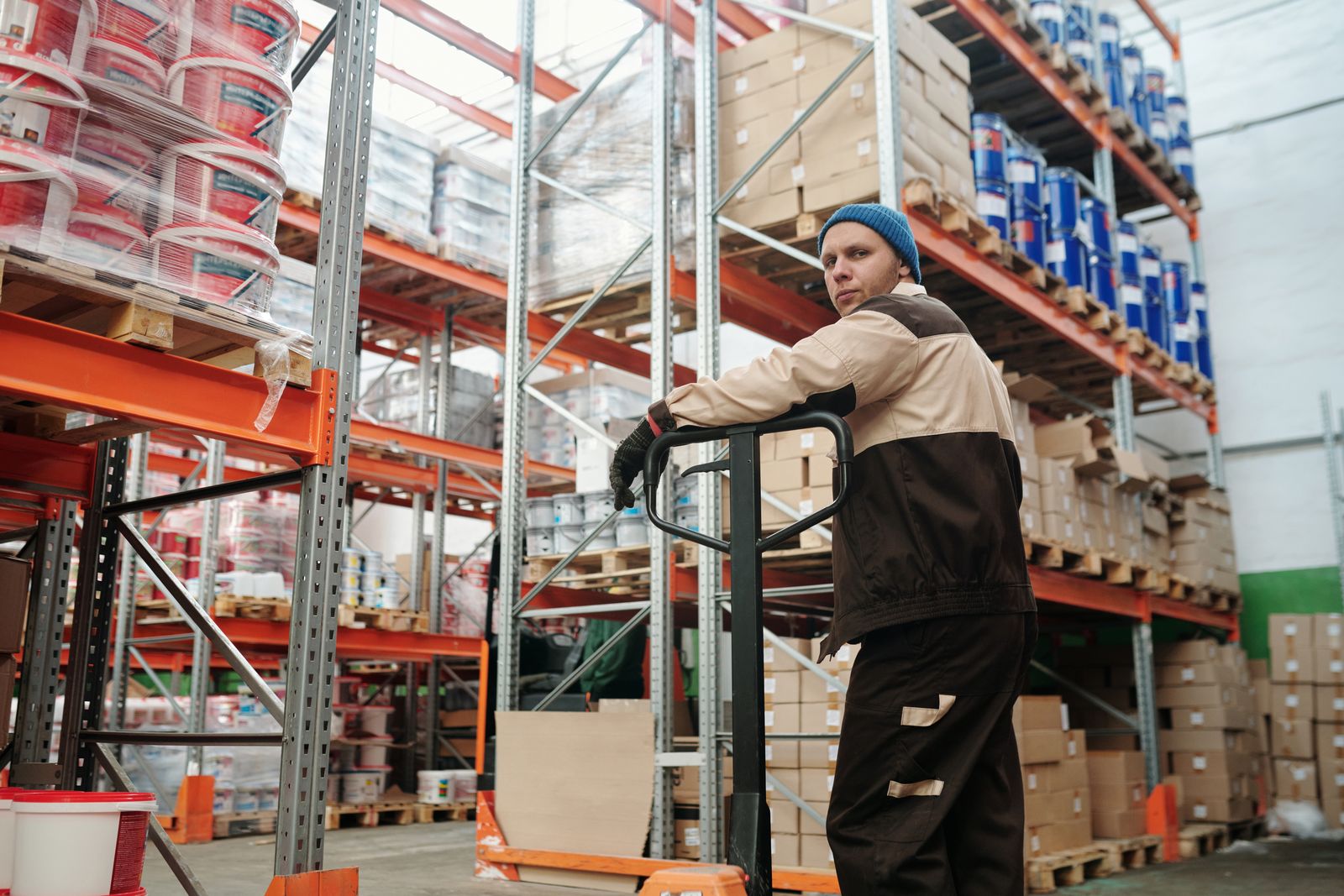 Warehouse worker moving boxed freight with a pallet jack